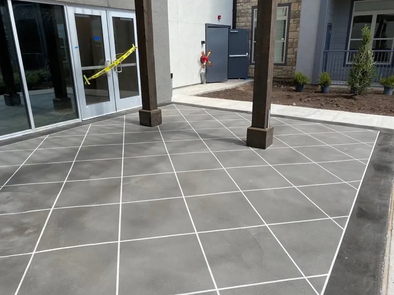 Scored polymer overlay outdoor patio in grey with white pattern