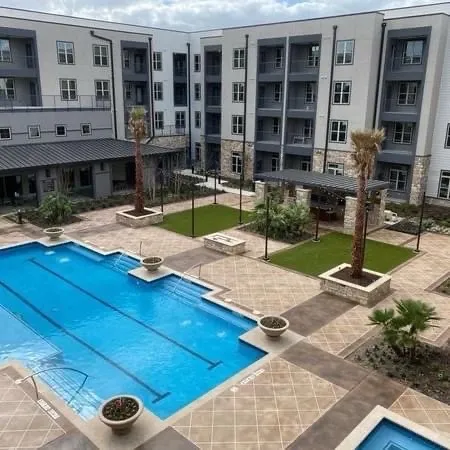 Large apartment courtyard pool deck finished with a decorative concrete overlay